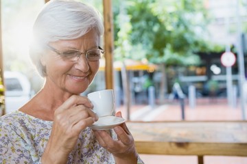 Happy senior woman having coffee