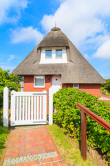 Fototapeta na wymiar Typical red brick house in Westerheide village with straw roof, Sylt island, Germany