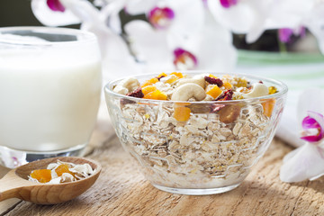 An ideal, healthy breakfast. Oatmeal on an old wooden table with flowers