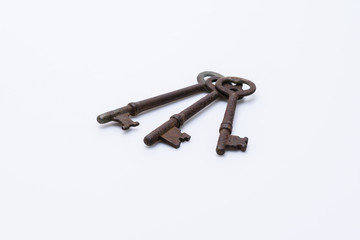 Three vintage keys in stack on white background
