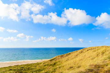 Grass sand dune and beautiful beach view with sunny clouds on sky, Sylt island, Germany