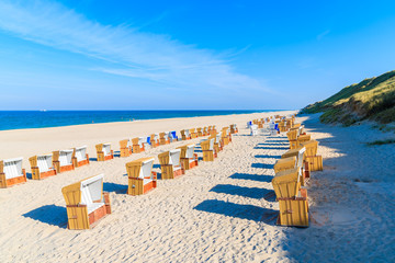Wicker chairs on sandy beach in Wenningsted village, Sylt island, Germany