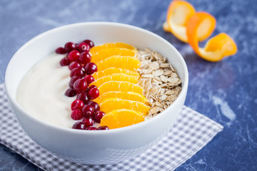 Homemade smoothie with berries, fruit  and oatmeal in a white bowl on marble table