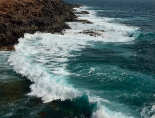 Littoral with groundswell and waves crashing against the rocks