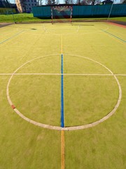 Obraz premium Empty outdoor handball playground, plastic hairy green surface on ground and white blue bounds lines.