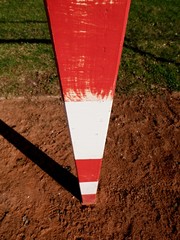 Detail of gate frame . Outdoor football or handball playground, light red crushed bricks surface on...