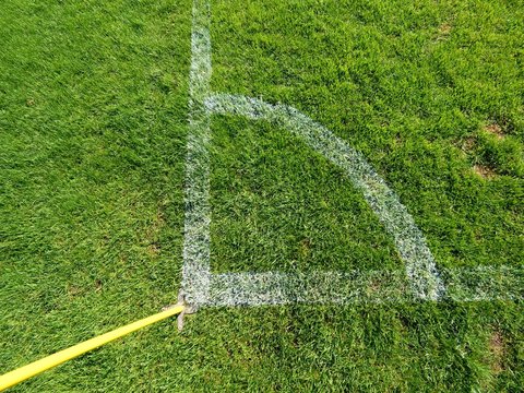 Football field corner detail with white marks and flag stick