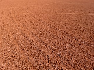 Dry light red crushed bricks surface on outdoor tennis ground