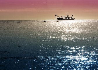 Obraz premium composizione colori fotografica alba pesca peschereccio illuminato raggi del sole