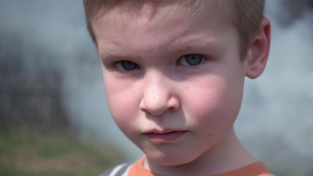 Smiling little boy against smoke fume clouds at the country side. Happy childhood and world cognition concept.