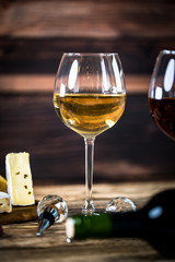 Glass bottle of wine with corks on wooden rustic table, place for typography