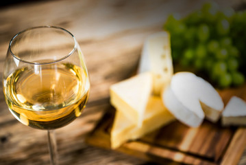 Wine bottles with grapes and cheese  on wooden rustic background. copy space