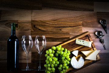 Obraz premium Wine bottles with grapes and cheese on wooden rustic background. copy space