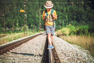 Little boy with backpack walks on railway track © Soloviova Liudmyla