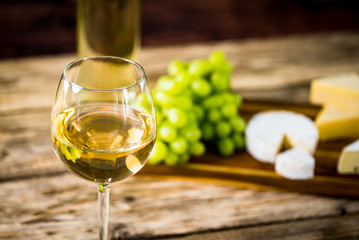  Wine bottles with grapes and cheese on wooden rustic background. copy space