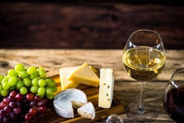  Wine bottles with grapes and cheese on wooden rustic background. copy space