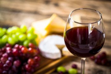  Wine bottles with grapes and cheese on wooden rustic background. copy space