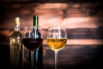 Glass bottle of wine with corks on wooden rustic table, place for typography