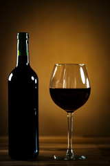 Glass bottle of wine with corks on wooden rustic table, place for typography