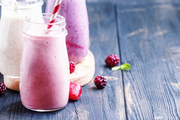 Berry smoothies with yoghurt, gray background, selective focus