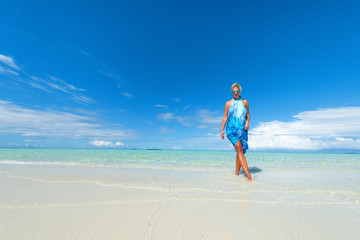 Blonde woman walking on the tropical beach.Copy space