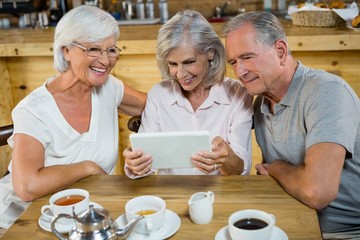 Group of senior friends using digital tablet