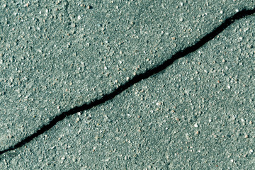 Obraz premium Crack on cyan asphalt surface.