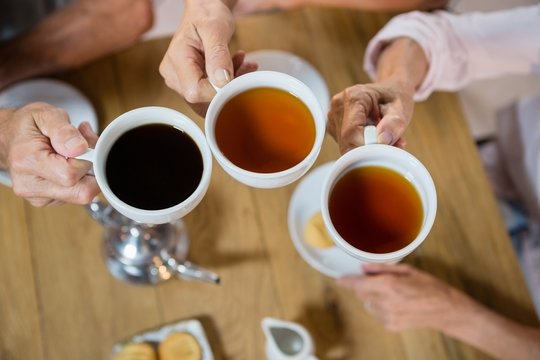 Group of senior friends toasting coffee cups