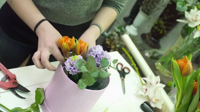 Florist creating a beautiful bouquet with orange tulps