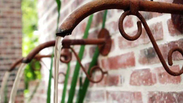 Water flowing from rustic pipe