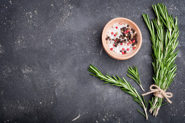 Herbs and spices. Rosemary, salt and pepper on concrete table. Cooking ingredients. Top view and...