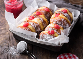 Homemade yeast donuts filled with rhubarb jam on rustic background. Close-up