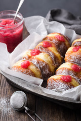 Homemade yeast donuts filled with rhubarb jam on rustic background. Close-up