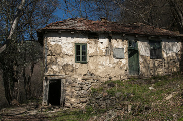 Old abandoned grunge rural country house in springtime mountain