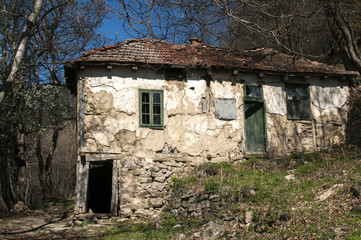 Old abandoned grunge rural country house in springtime mountain