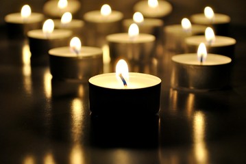 Candles light; candle flames background; selective focus.