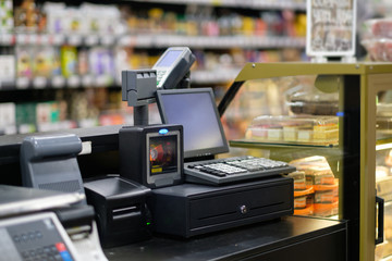 Cash desk with computer screen and card payment terminal in bakery department in store