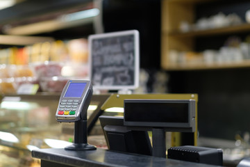 Cash desk with card payment terminal and infromation screen in small cafe