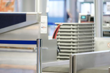 Waiting line in front of check-in desk with pile of luggage baskets in airport