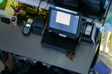 Cash desk terminal with screen and cash box in small cafe from top