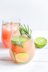 fitness cocktail in glass with lime and rosemary on white table background