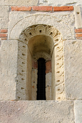 Fototapeta na wymiar chiesa romanica dei Santi Nazario e Celso a Montechiaro d'Asti; monofora con strombo e decorazioni