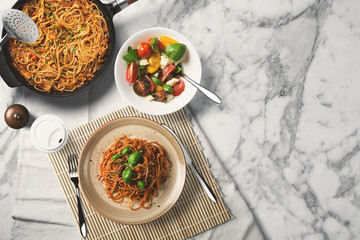 Pasta and salad, wooden desk, top view.