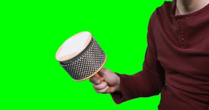 Mid section of male musician playing cabasa