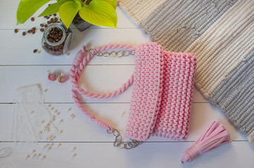 Female handbag handmade pink color on a white background with a jar of coffee and beads