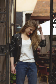 Young blonde woman dressed in stylish jacket and jeans at the street