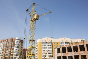 Fototapeta na wymiar Tower crane on construction site on the background of new residential buildings