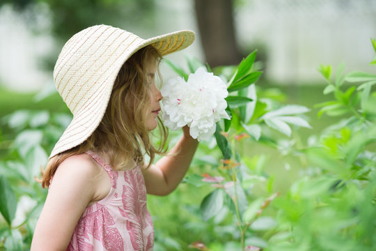 Young girl smelling flower outside