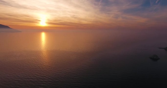 Aerial shot of beautiful sunset on the calm sea in Elba island in Tuscany, Italy, 4K