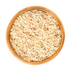 Sparkling Volcano Terra rice in wooden bowl. Brown, red and pink natural rice. Rice of warriors from Tasikmalaja region of West Java. Isolated macro food photo close up from above on white background.